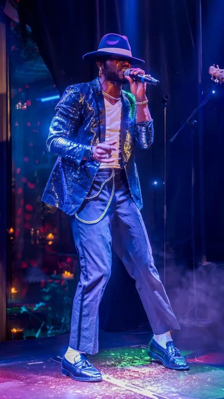 Cantante del live band con traje de lentejuelas actuando en el escenario del Palais Jad Mahal