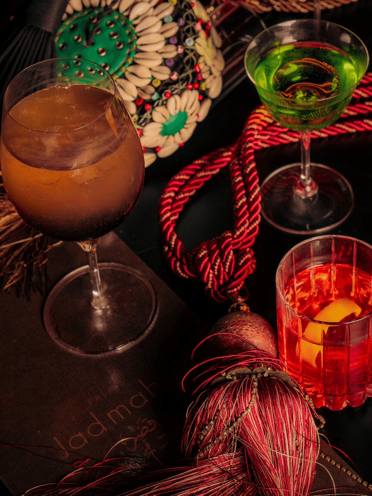 Trio de cocktails signatures colorés dans une ambiance tamisée