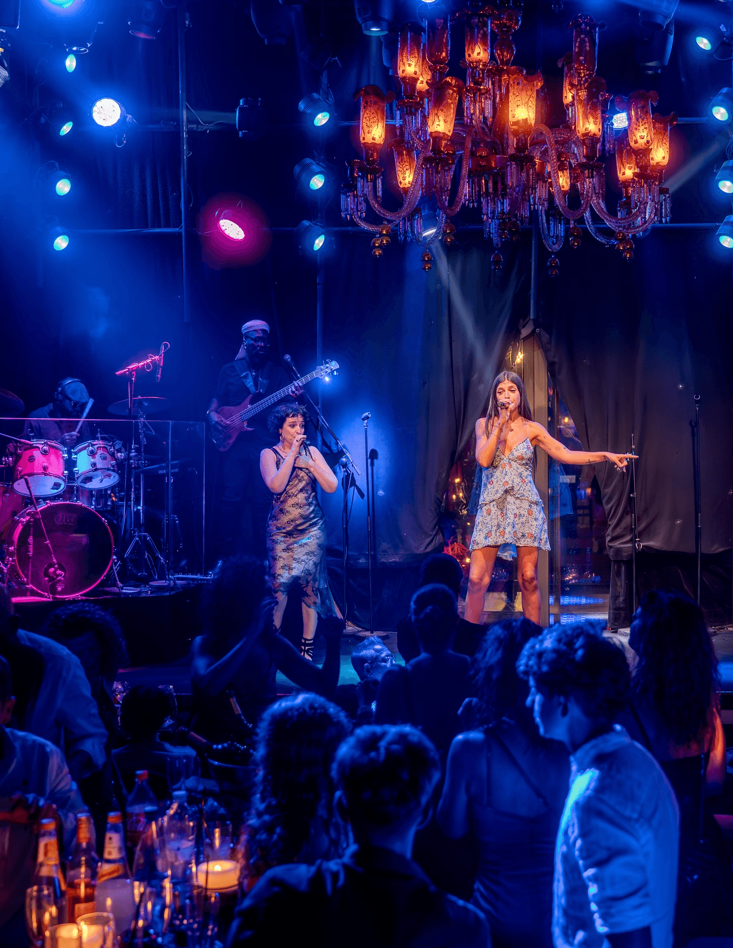 Deux chanteuses sur scène réalisent un concert sous des lumières bleues.